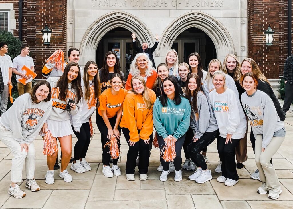 Jules with students in Tennessee sweatshirts in front of the Haslam College of Business
