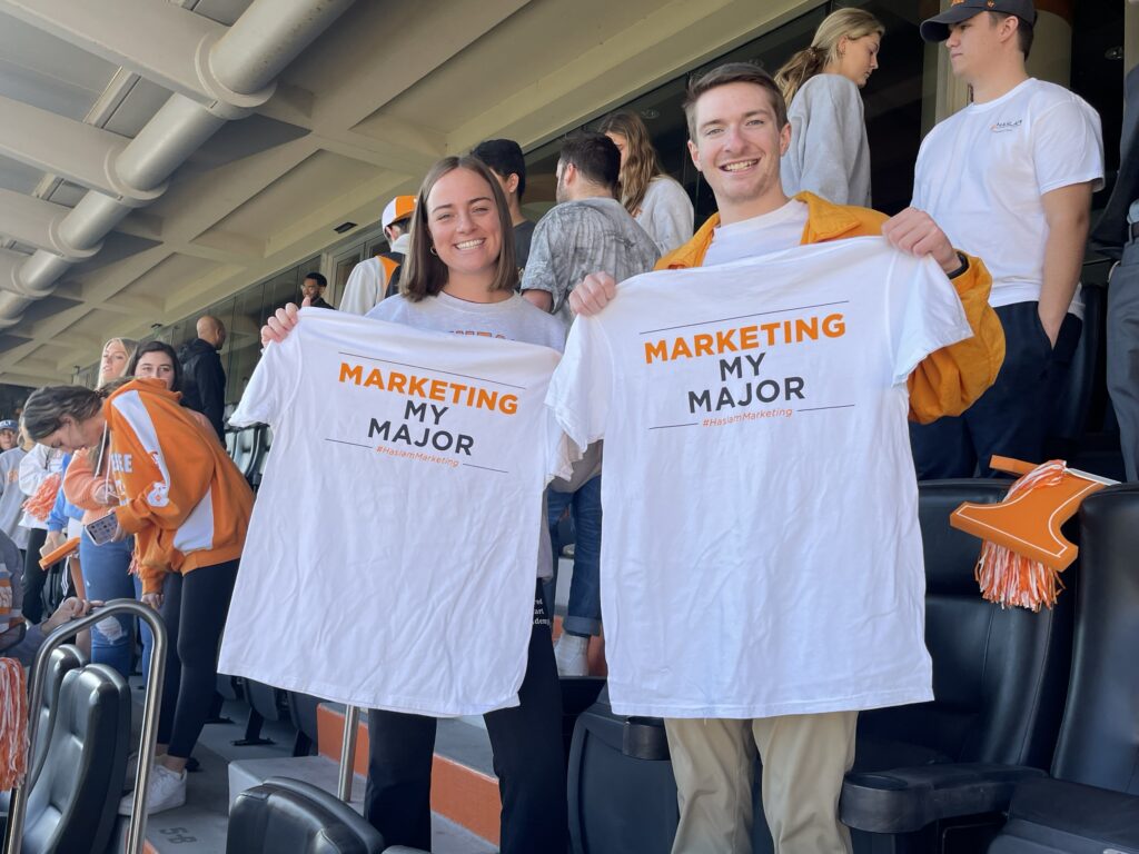 Two students at a Tennessee football game holding Marketing My Major T-shirts