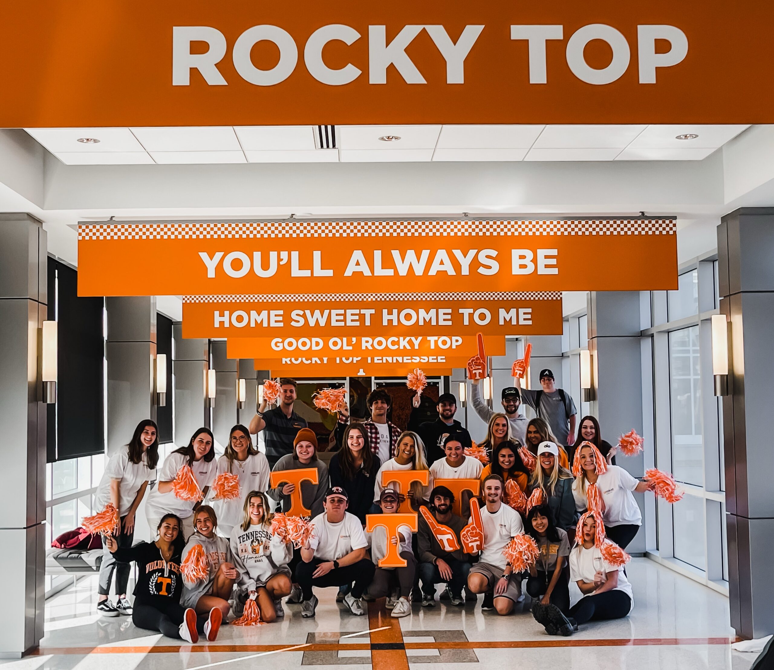 A class cheering with foam fingers and orange T signs under Rocky Top banners