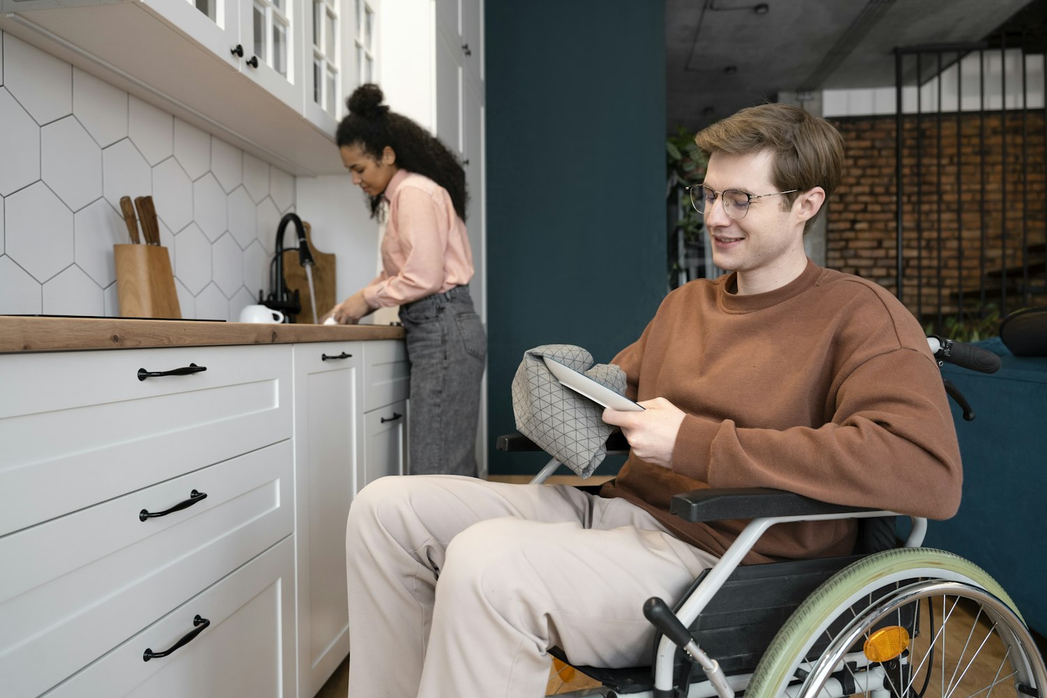 A man in a wheelchair using a laptop at home