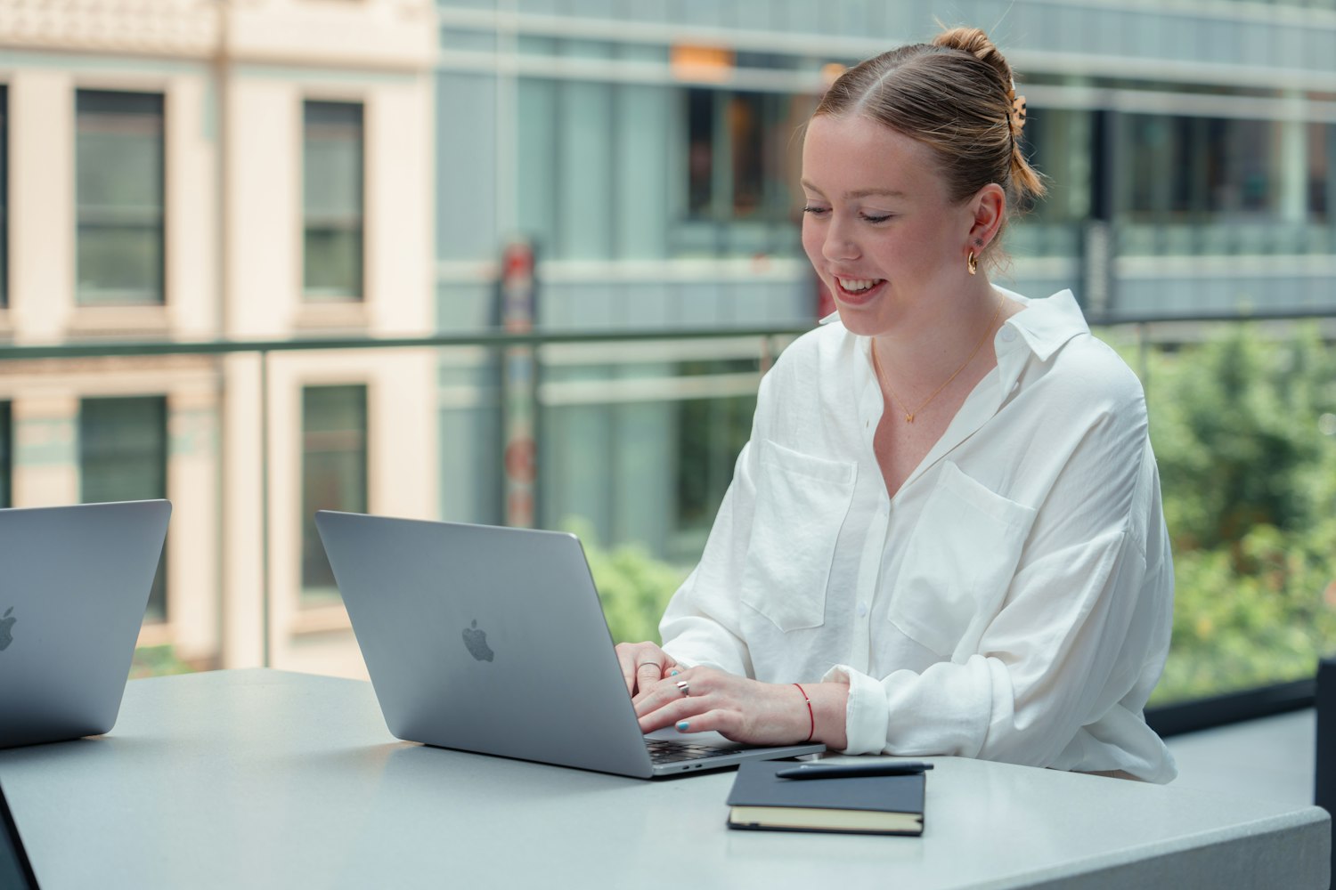 A young professional working on a laptop by a bright window