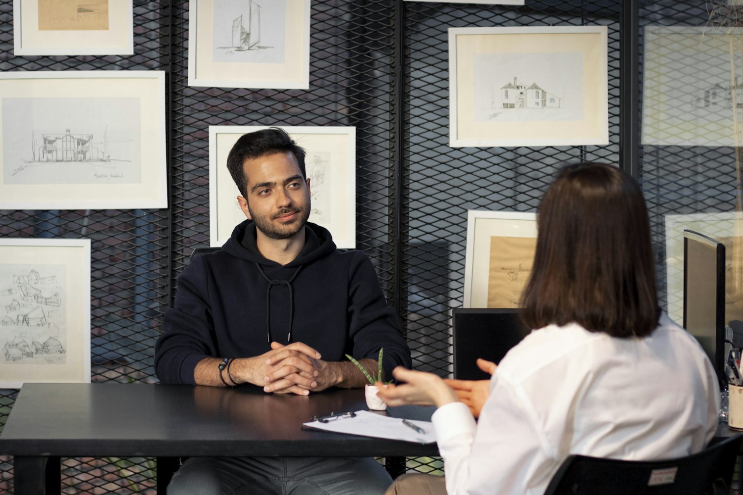 Two people talking across a desk during a research interview