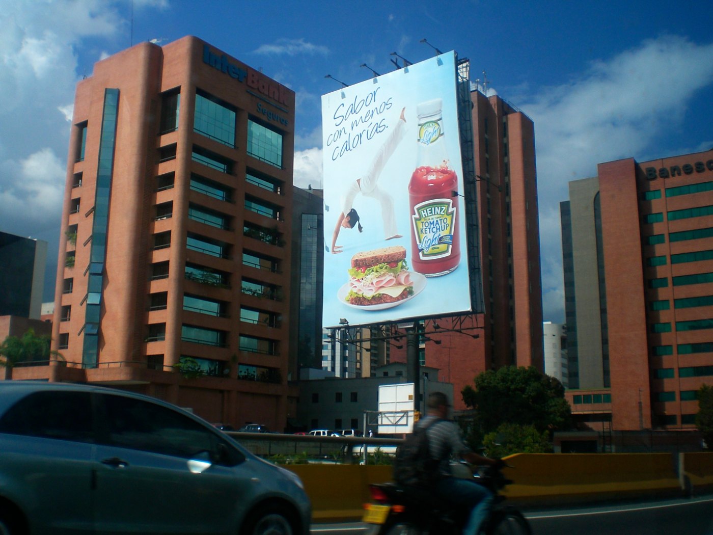 A large Heinz ketchup billboard on the side of a city building