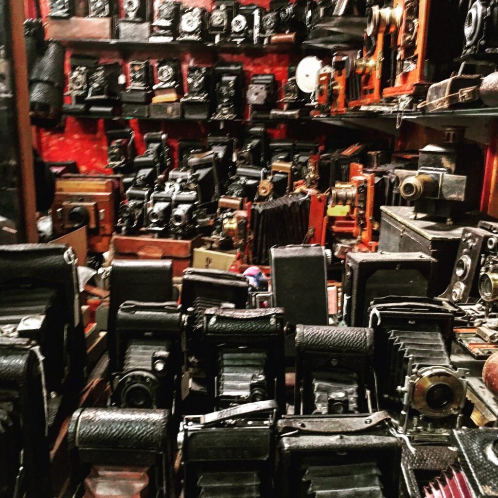 A shop wall packed with hundreds of vintage cameras
