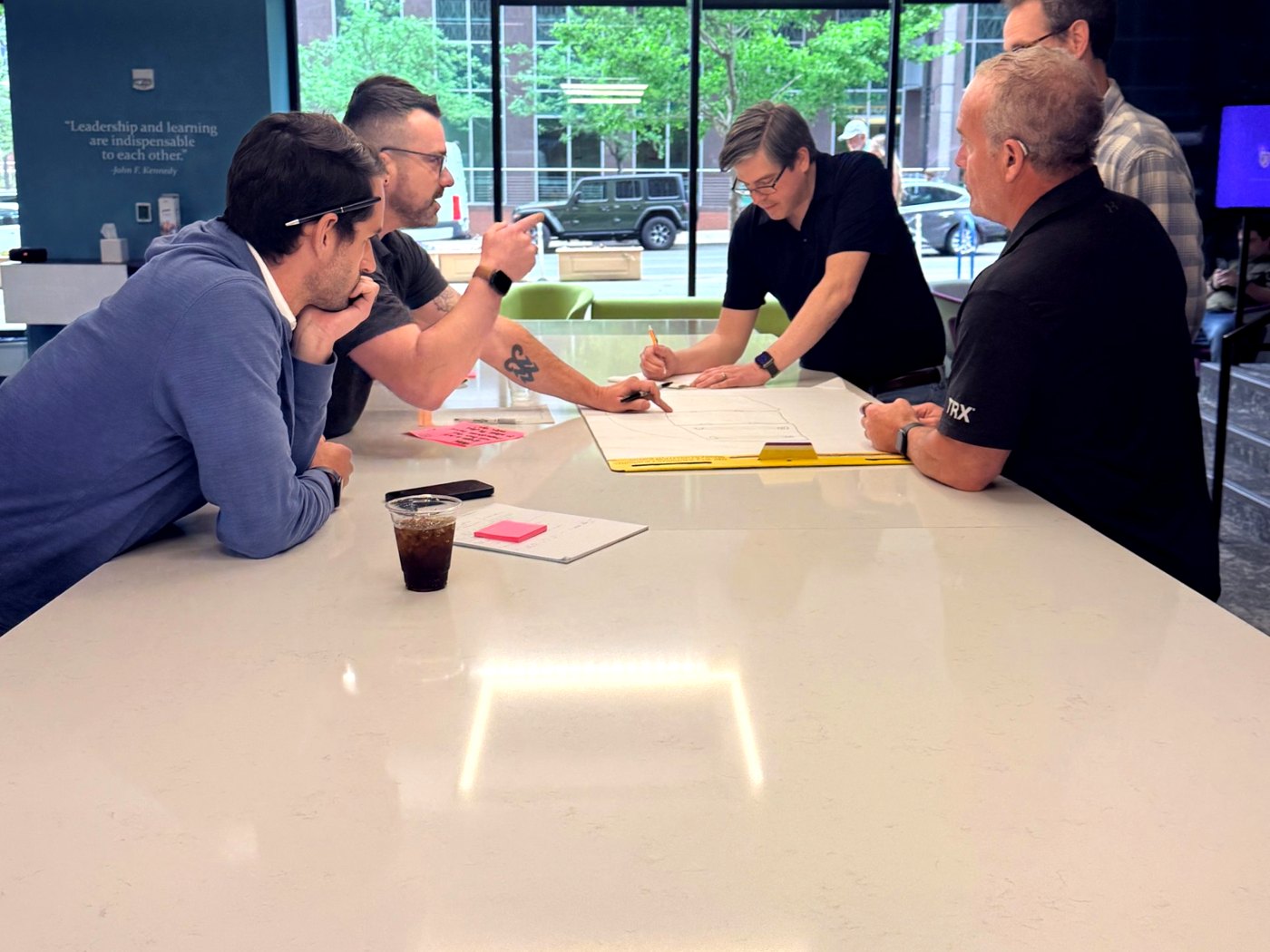 MBA students mapping ideas on a large sheet of paper at a workshop table