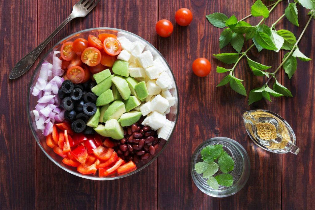 A colorful bowl of fruit and vegetables on a wooden table