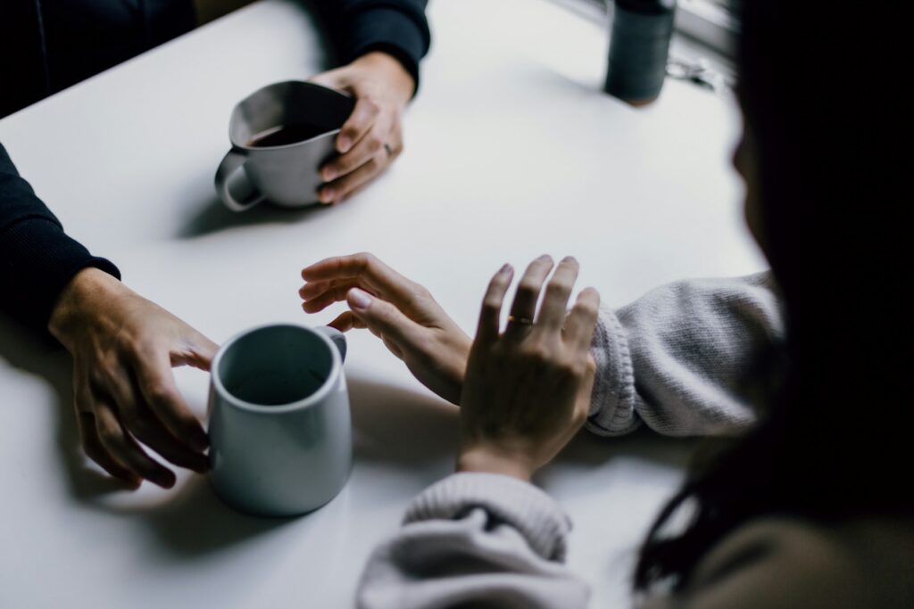 Colleagues talking over coffee at a white table