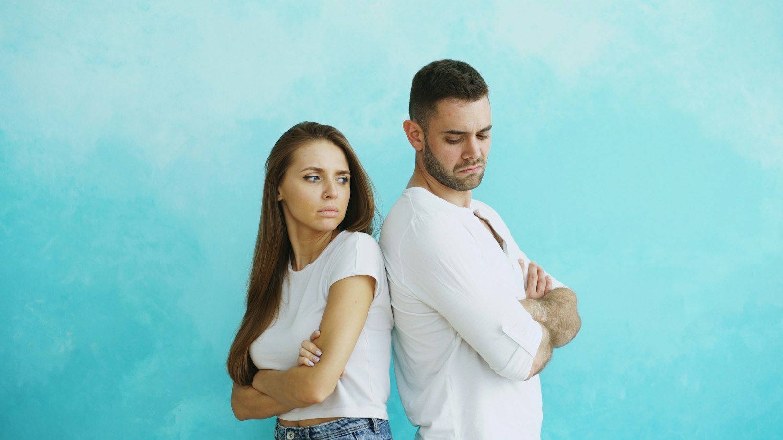 A couple standing back to back with arms crossed after an argument