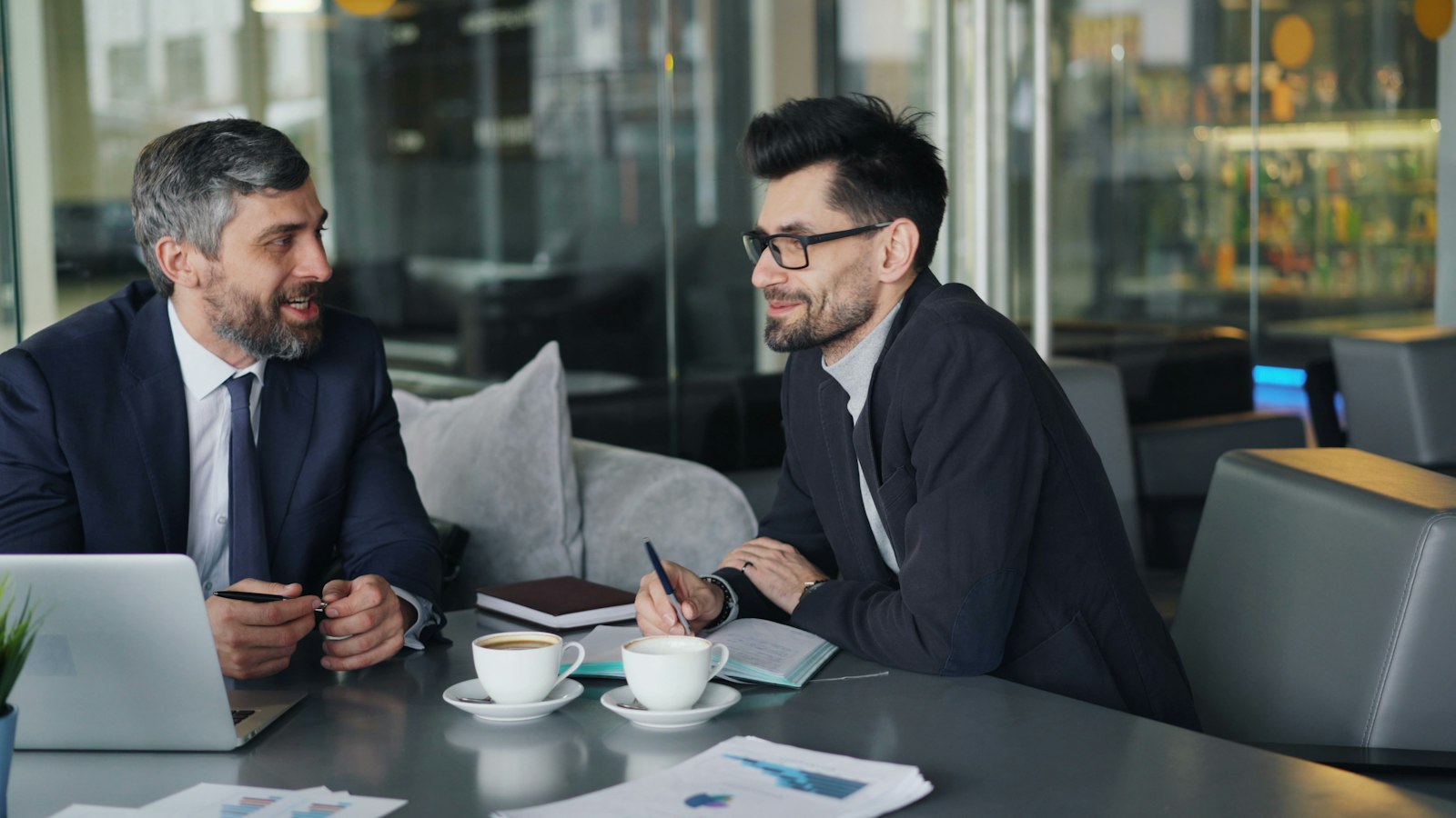 Two colleagues in a focused one-on-one conversation over coffee