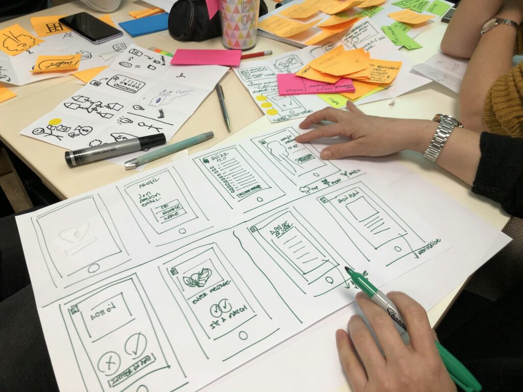 People sketching ideas on paper around a table