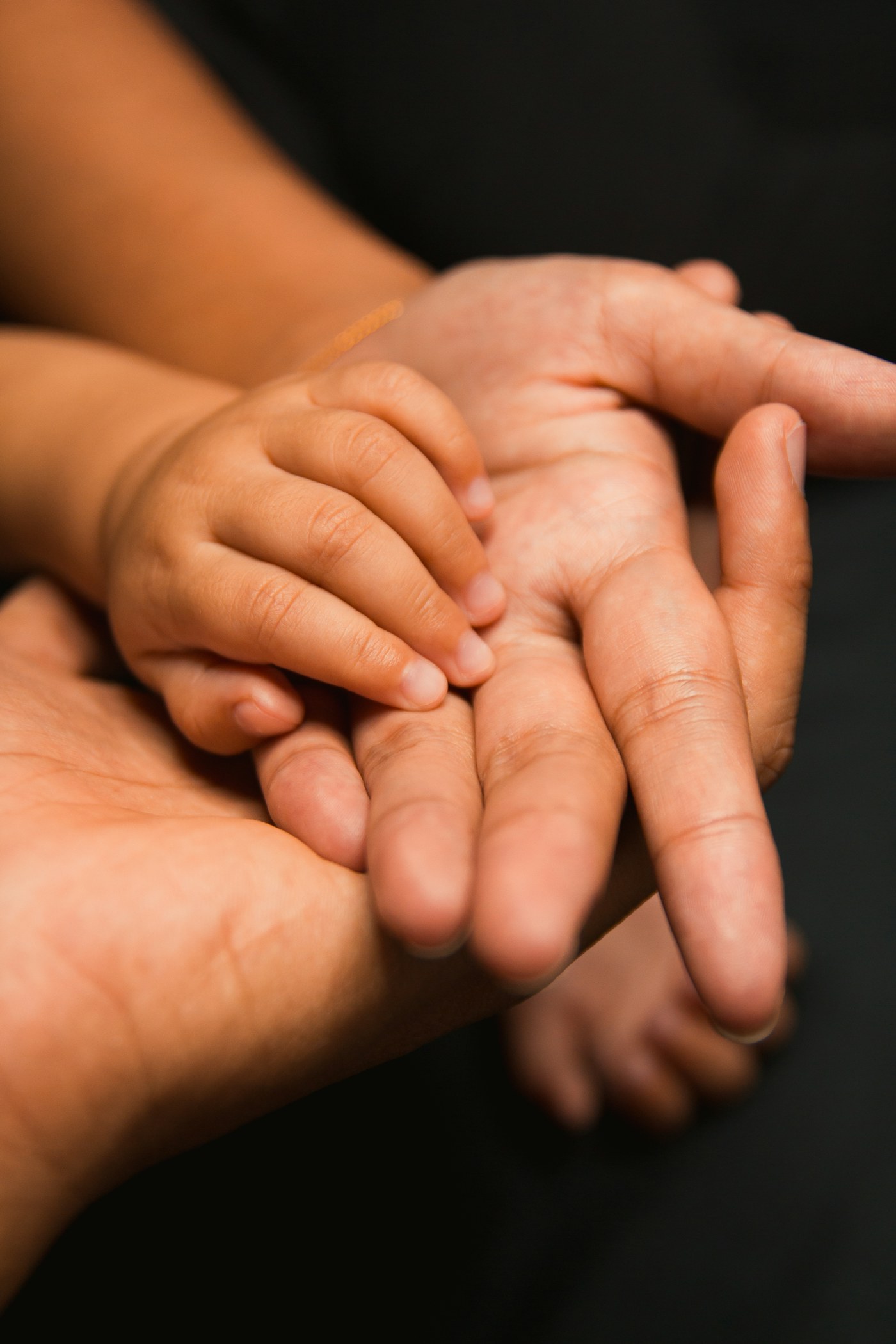A small child's hand resting in an adult's open palm