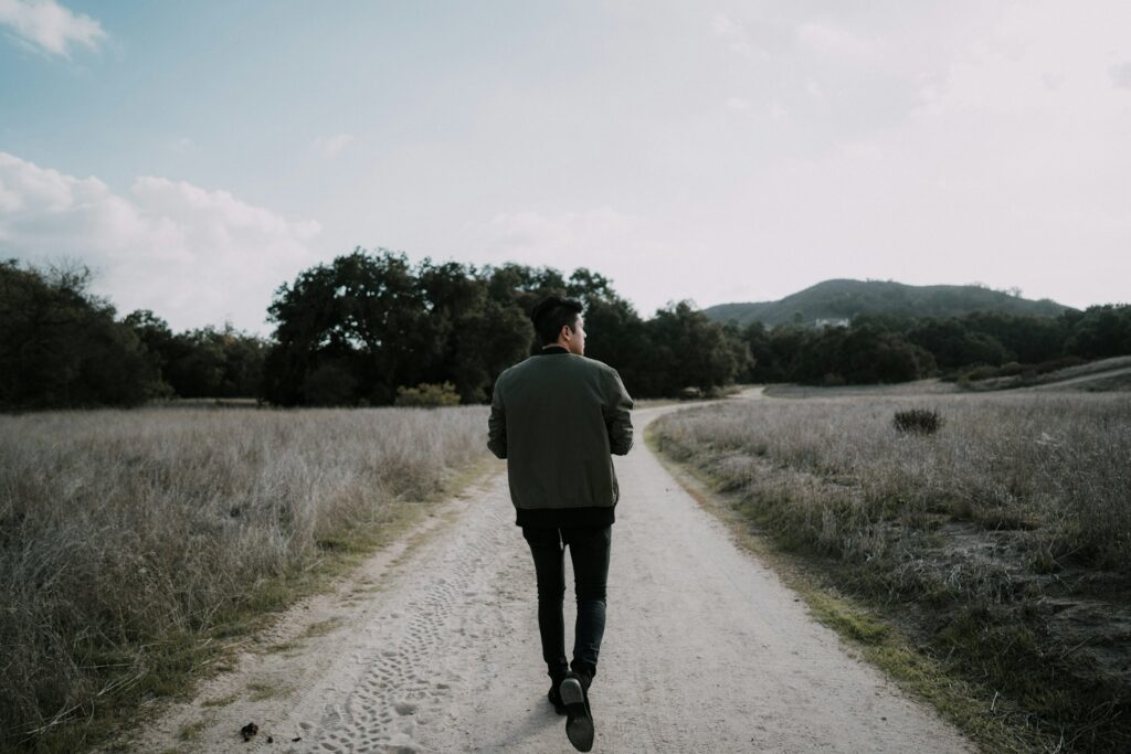 A man walking alone down an empty country road