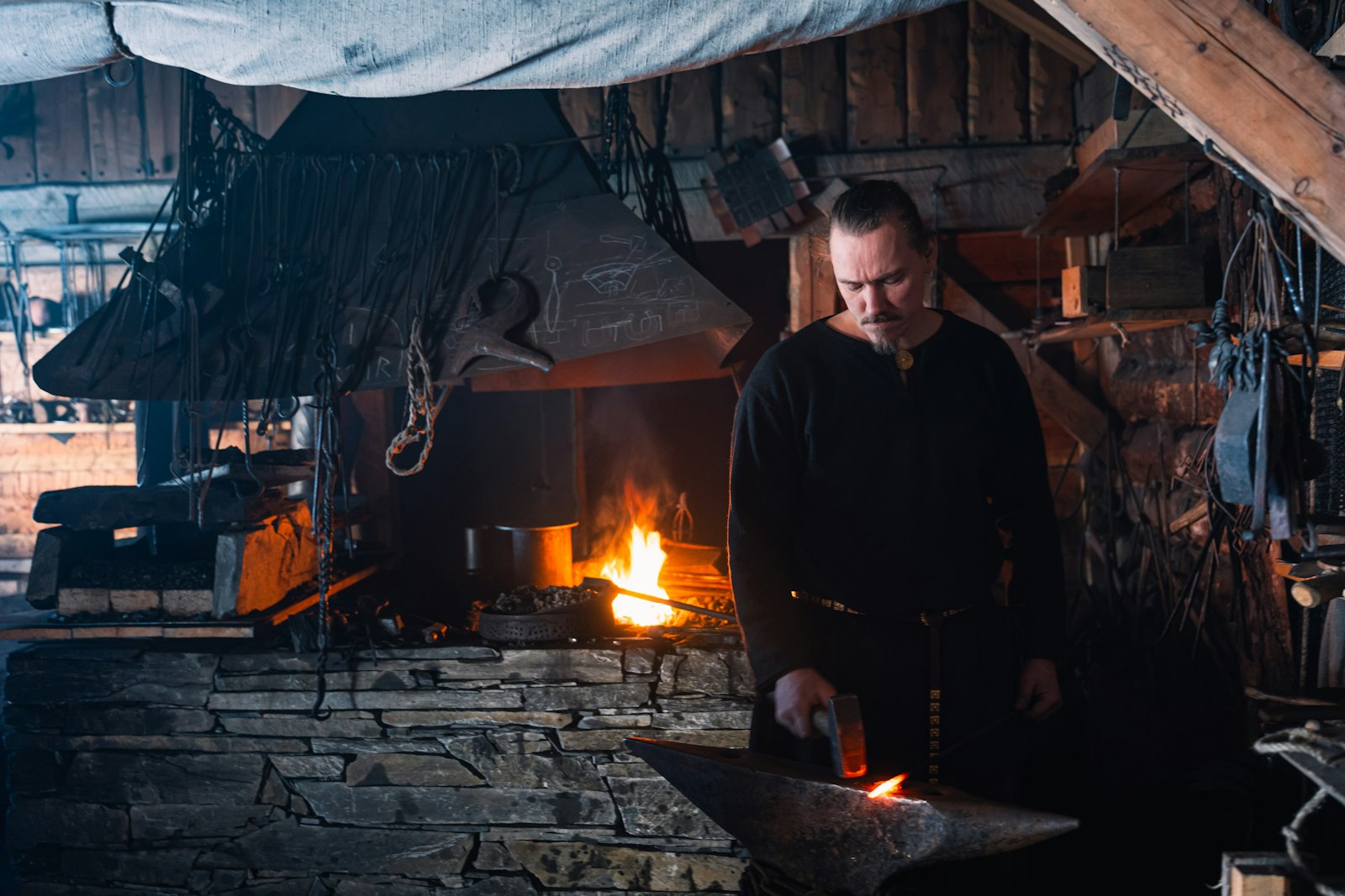 A blacksmith working at a glowing forge