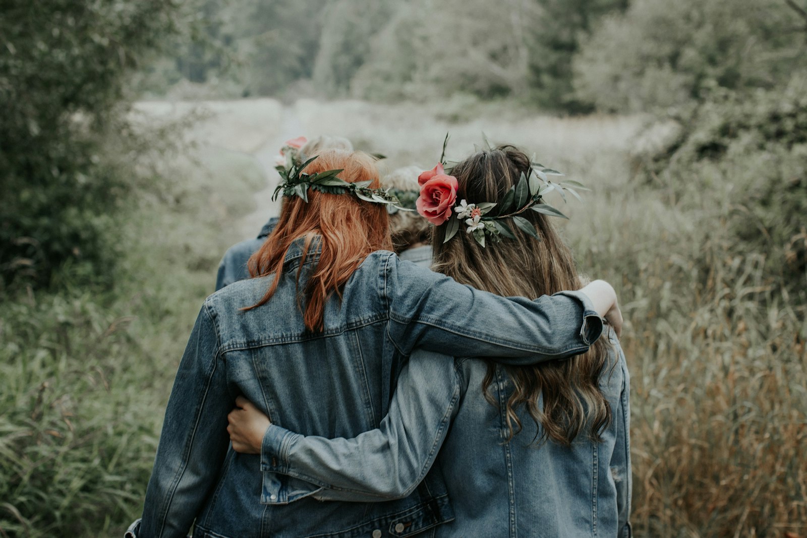 Friends embracing in a field, one comforting the other