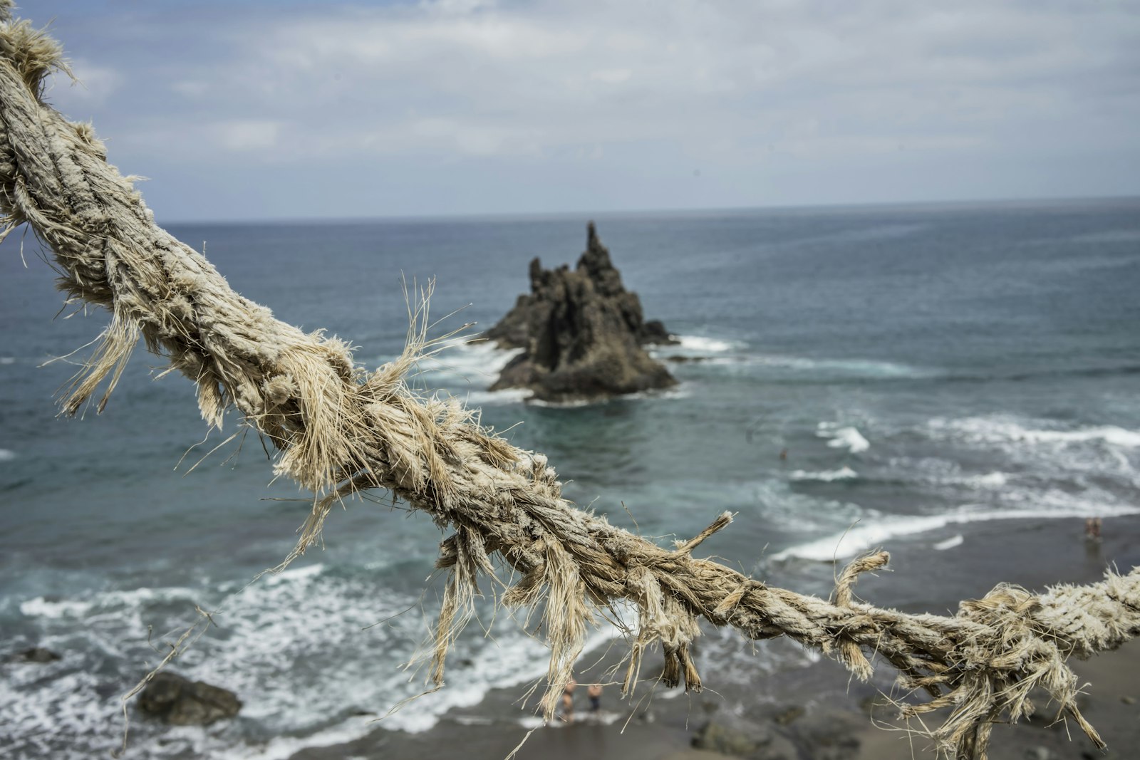 A frayed rope stretched taut above the sea