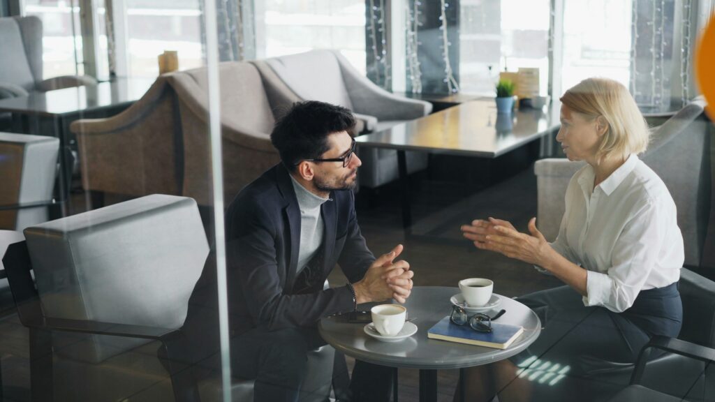 A manager and an employee reviewing work together in an office