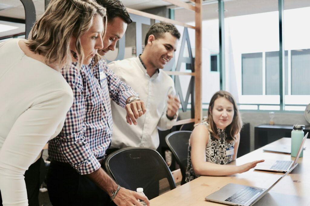 A team gathered around a laptop, working through a plan together