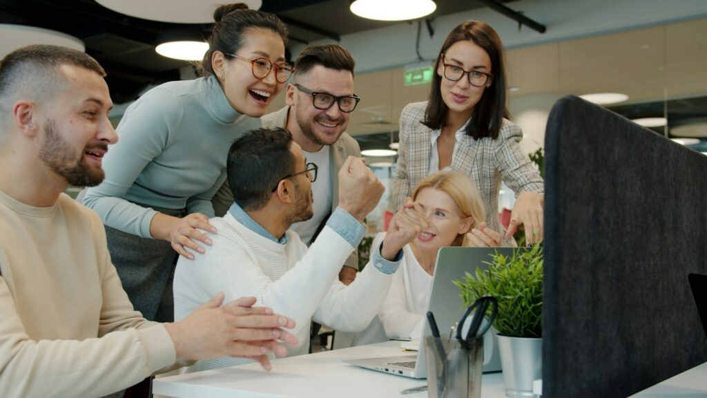 Colleagues laughing and celebrating together at work