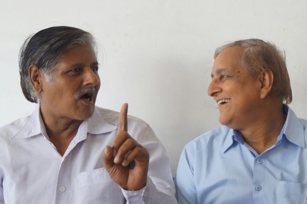 Two older colleagues sharing a laugh in conversation