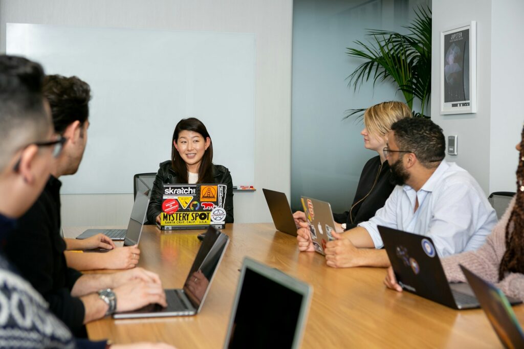 A team meeting around a table, one person speaking while others listen