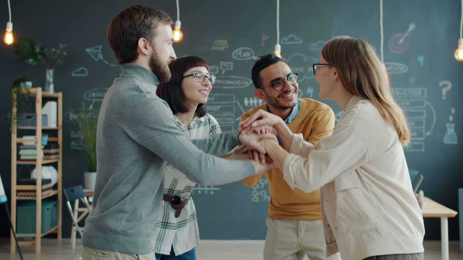 Colleagues celebrating together with a high five in the office