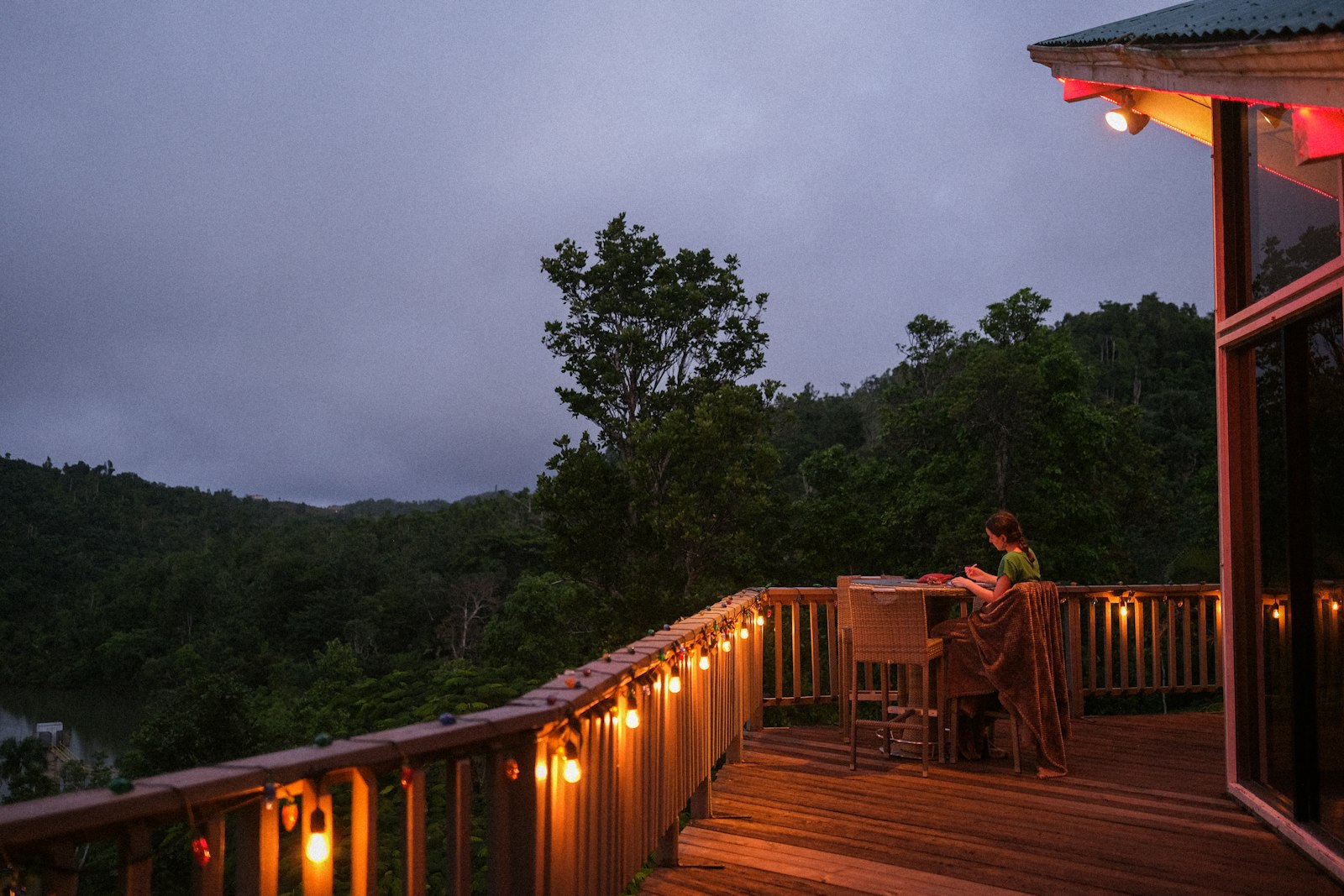 A quiet deck at dusk overlooking wooded hills