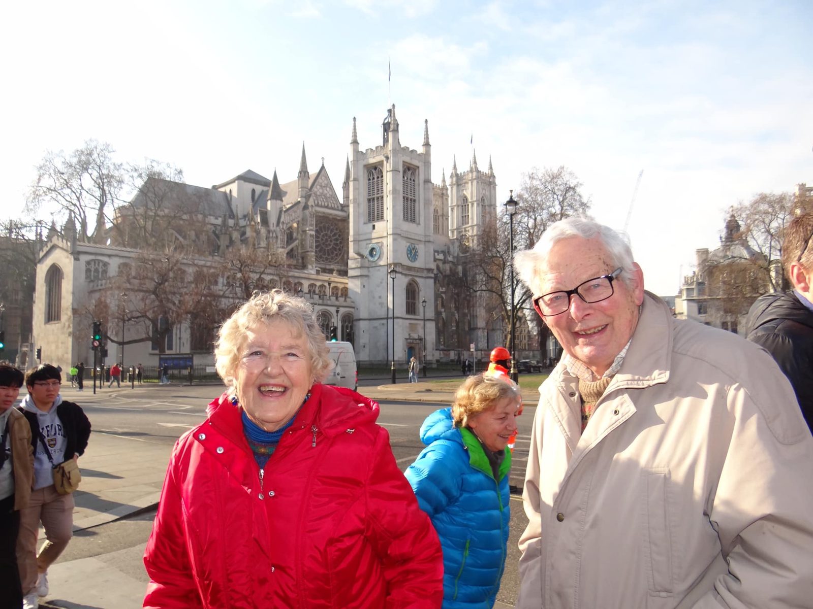 A student interviews an older couple in front of Westminster Abbey