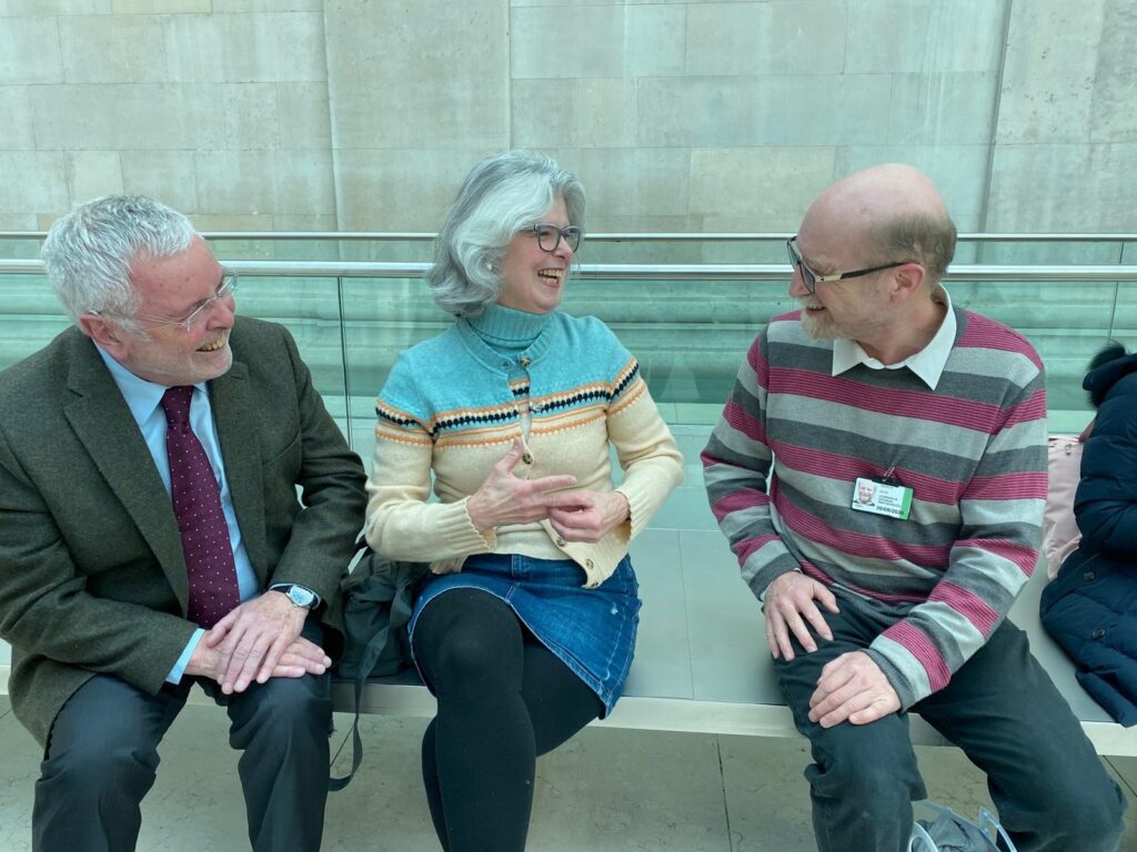 Students sit and talk with three older visitors inside the British Museum