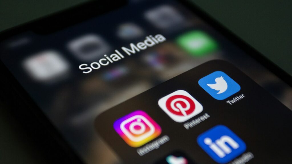 A close up of a cell phone with social media icons on it