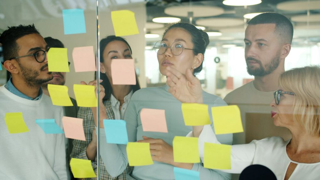 Diverse team collaborating on sticky notes