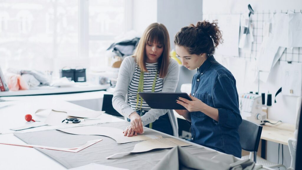 Two fashion designers collaborating on a design