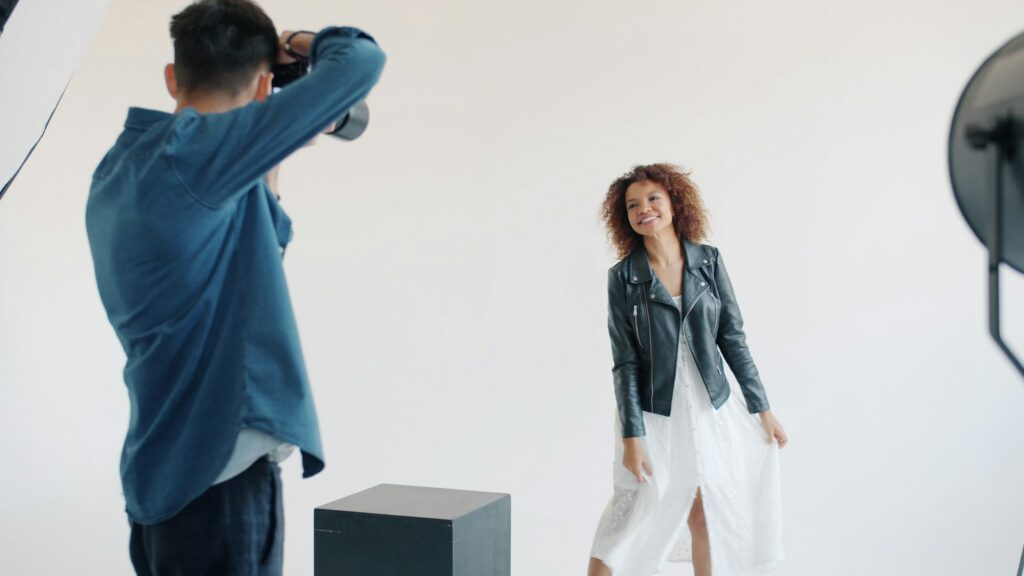Model poses for photographer in studio setting