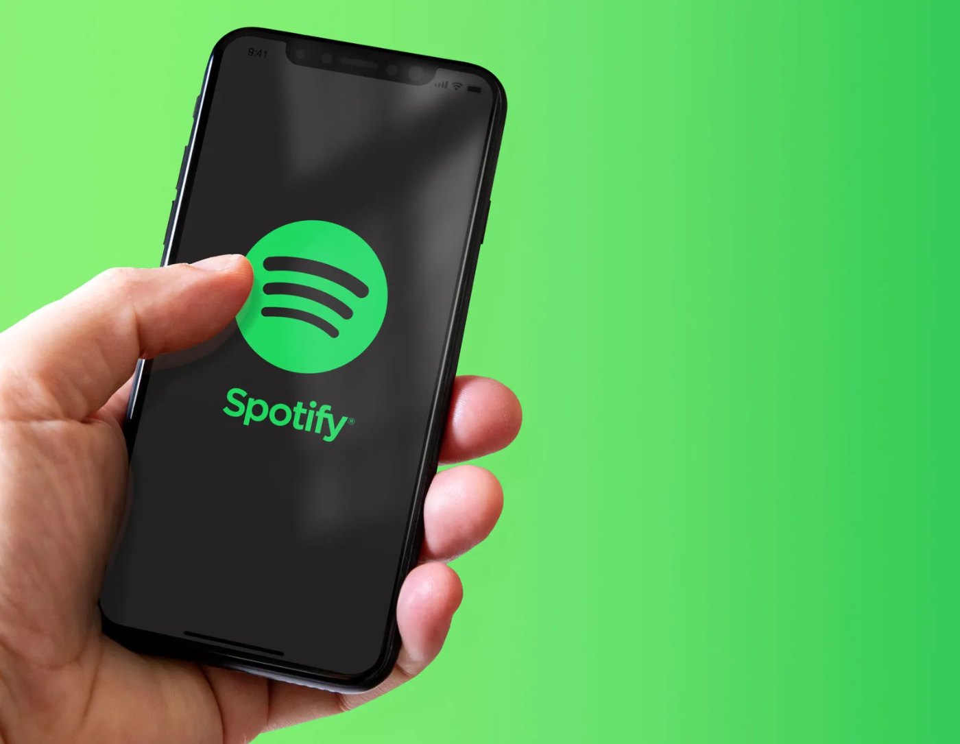 A hand holding a phone showing the Spotify logo against a bright green background