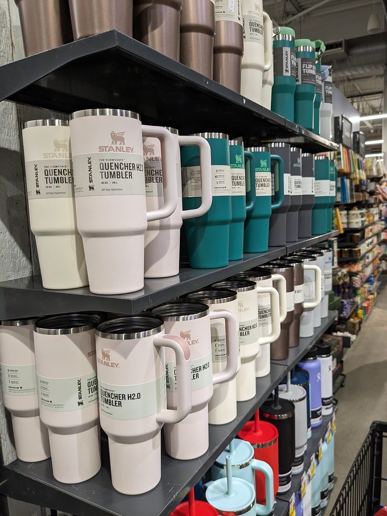 A store shelf lined with Stanley Quencher tumblers in many colors