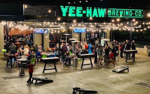 Crowds and string lights at Yee-Haw Brewing's outdoor space at night